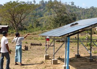 2014年ソーラーパネルの埃取りをする保守担当者(ミャンマーカレン州)